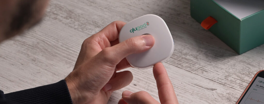 voorbeeld van de Qlupod wearable, een persoon die met een vinger het test